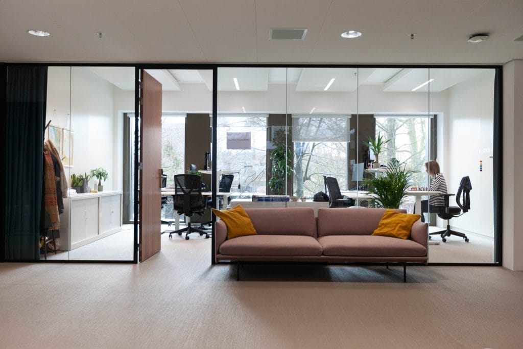 Comfortable office with upcycled furniture and a biophilic design that includes plants, natural colors and materials